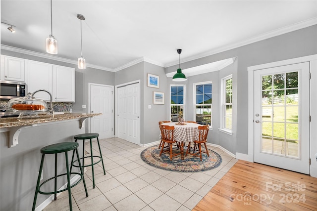 tiled dining room featuring crown molding