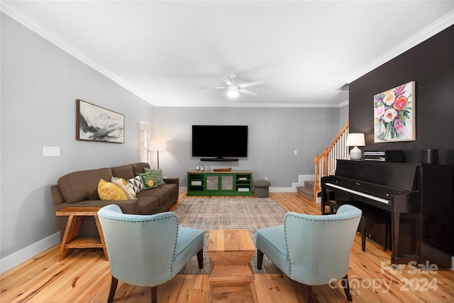 living room featuring light hardwood / wood-style floors, ceiling fan, and crown molding