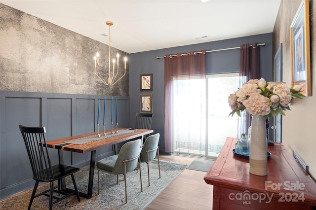 dining area with a chandelier, plenty of natural light, and wood-type flooring