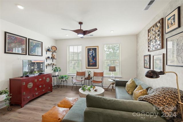 living room featuring light hardwood / wood-style flooring and ceiling fan