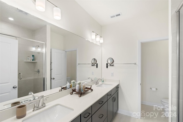 bathroom featuring vanity, toilet, and a shower with door