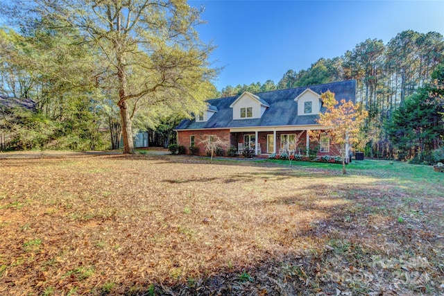 new england style home with a porch and a front yard