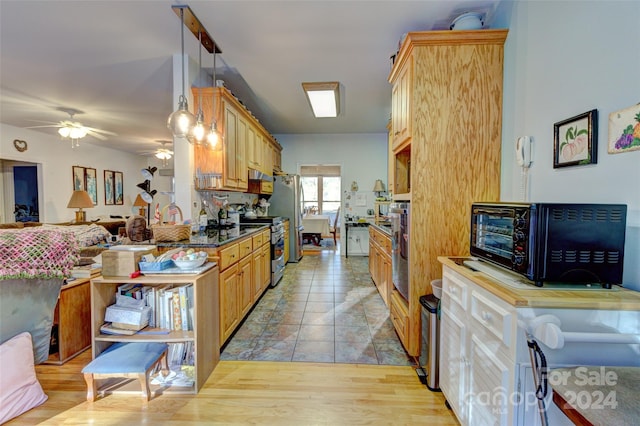 kitchen featuring light wood-type flooring, decorative light fixtures, ceiling fan, and stainless steel range with electric cooktop