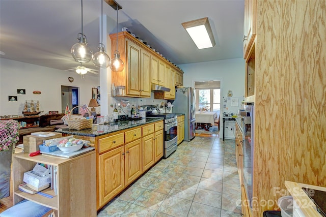 kitchen with stainless steel appliances, ceiling fan, dark stone countertops, hanging light fixtures, and light tile patterned flooring