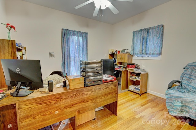 home office with light wood-type flooring and ceiling fan