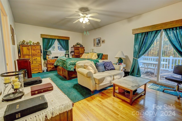 bedroom featuring hardwood / wood-style flooring, ceiling fan, access to exterior, and multiple windows