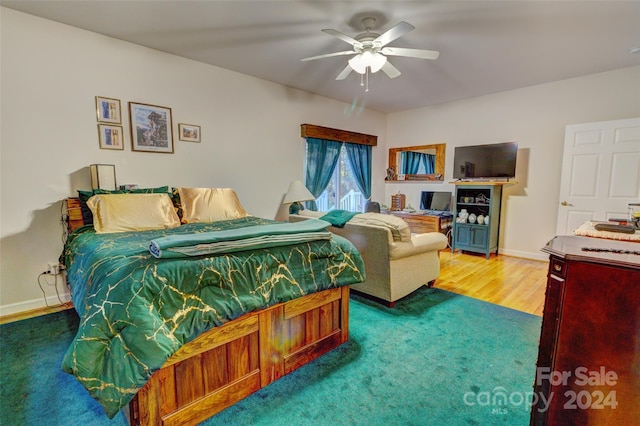 bedroom with hardwood / wood-style floors and ceiling fan