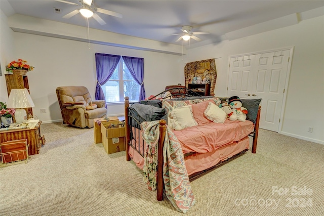 carpeted bedroom featuring ceiling fan, a fireplace, and a closet