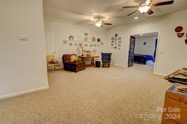 living area with carpet and ceiling fan