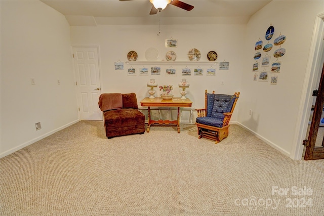 living area with light carpet and ceiling fan