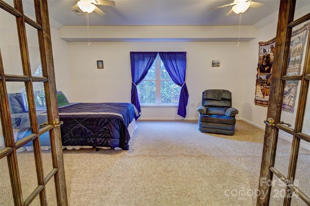 carpeted bedroom with beamed ceiling, ceiling fan, and french doors