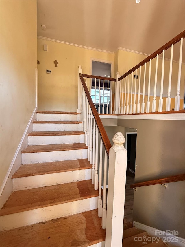 stairway featuring ornamental molding