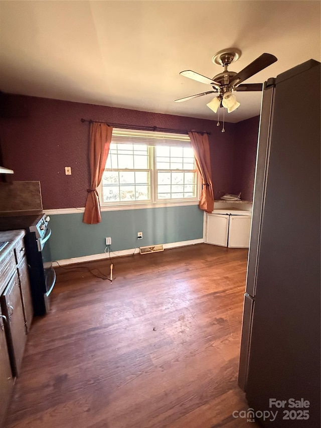 kitchen featuring ceiling fan, stainless steel fridge, and dark hardwood / wood-style floors