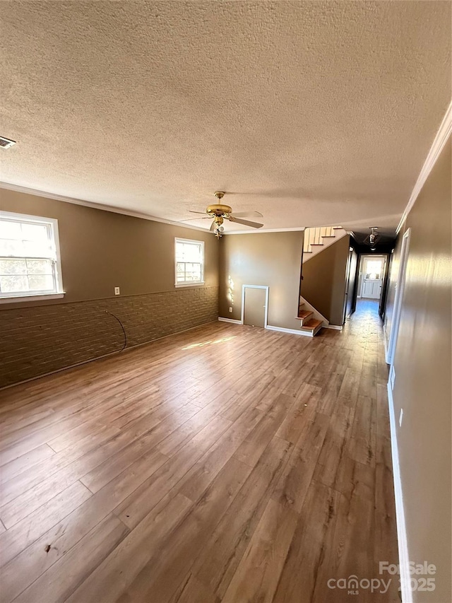 unfurnished room with ceiling fan, hardwood / wood-style floors, ornamental molding, and a textured ceiling