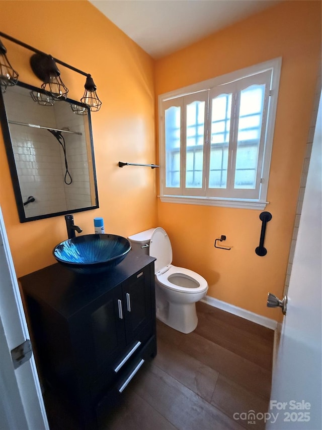 bathroom with toilet, wood-type flooring, and vanity