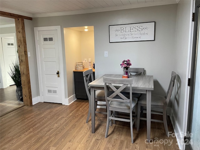 dining area featuring hardwood / wood-style flooring and crown molding