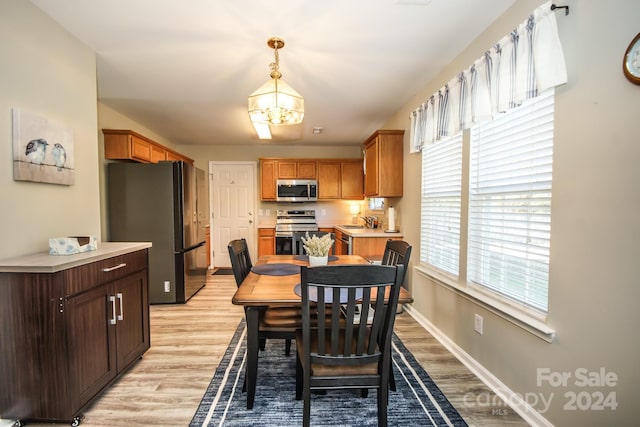 dining space with a chandelier, light hardwood / wood-style floors, and sink