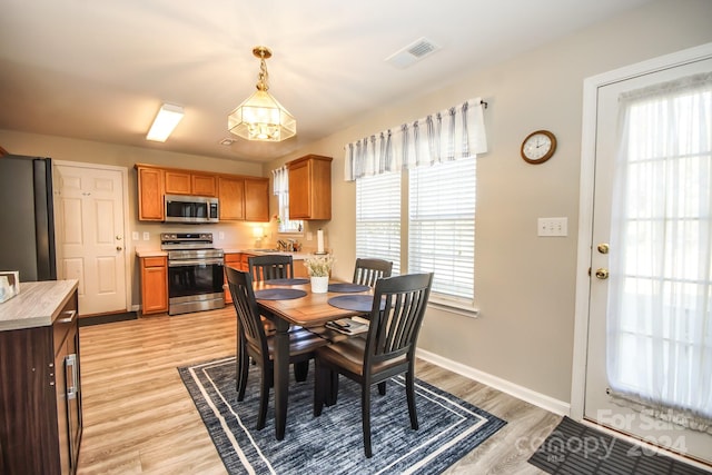 dining space featuring sink, a wealth of natural light, and light hardwood / wood-style flooring