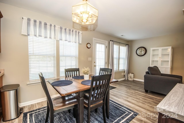 dining room with hardwood / wood-style flooring and a chandelier