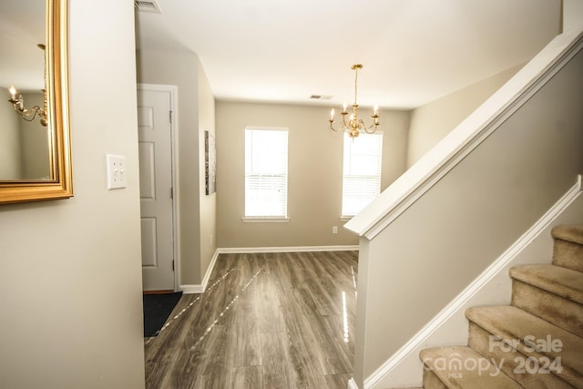 foyer with dark hardwood / wood-style flooring and a notable chandelier