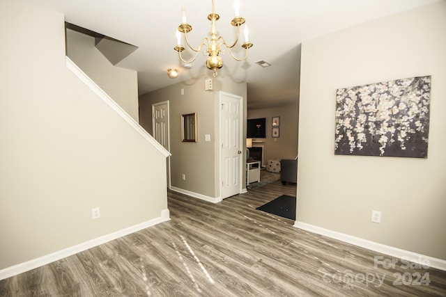 unfurnished dining area with hardwood / wood-style flooring and a notable chandelier