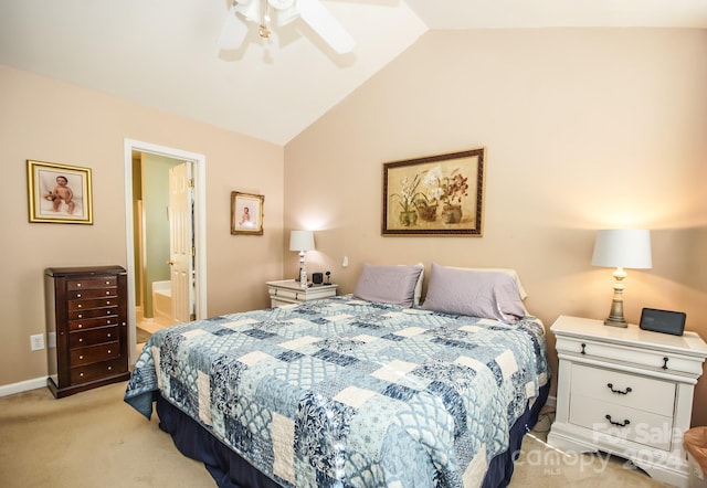 bedroom with ensuite bath, ceiling fan, light carpet, and vaulted ceiling