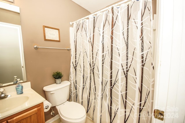 bathroom with vanity, curtained shower, and toilet