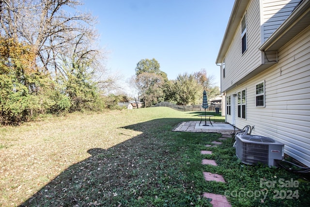 view of yard with central air condition unit and a patio