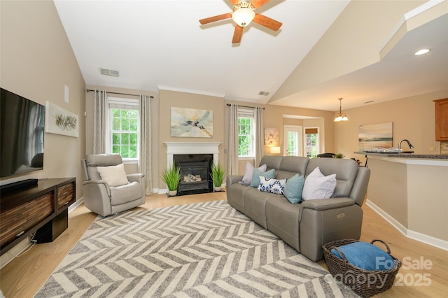 9618 Belloak Ln, Waxhaw, NC 28173 - living room with light wood-style floors, a fireplace with flush hearth, a ceiling fan, baseboards, and vaulted ceiling