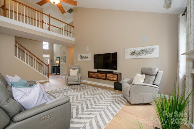 9618 Belloak Ln, Waxhaw, NC 28173 - living area featuring stairs, a ceiling fan, light wood-style flooring, and a high ceiling