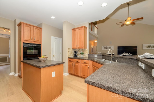9618 Belloak Ln, Waxhaw, NC 28173 - kitchen with oven, a sink, ceiling fan, dark countertops, and light wood-style floors