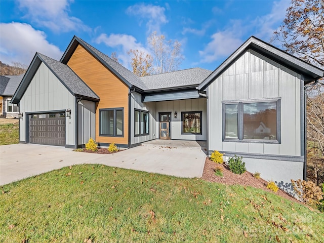 modern farmhouse style home with a front yard and a garage