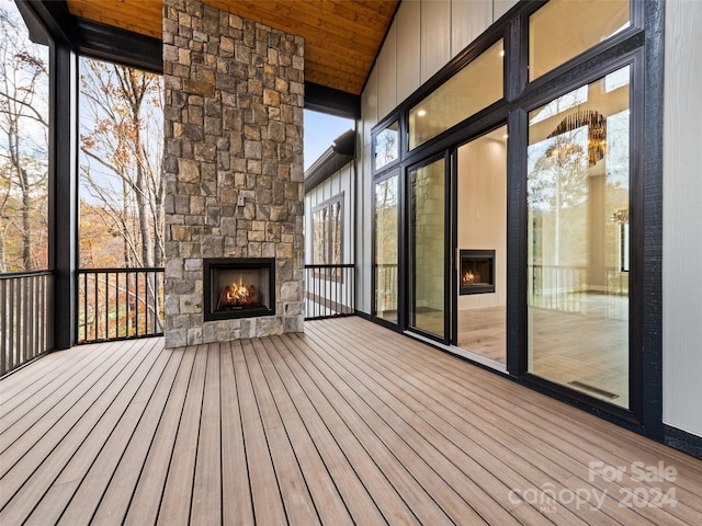 wooden terrace with an outdoor stone fireplace