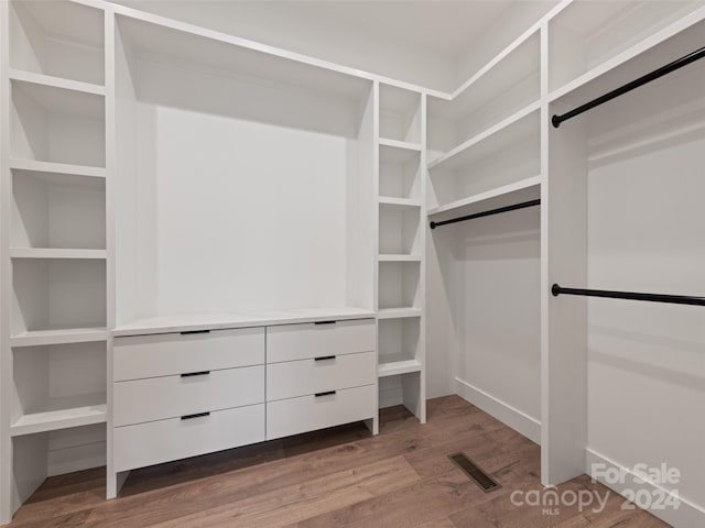 walk in closet with hardwood / wood-style flooring