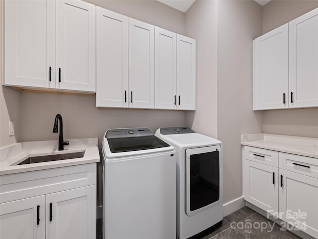 washroom with cabinets, sink, washer and dryer, and dark tile patterned flooring