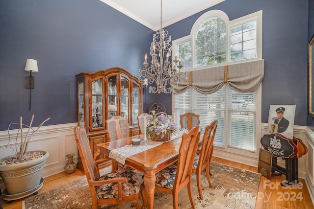 dining space featuring a chandelier, ornamental molding, and hardwood / wood-style flooring