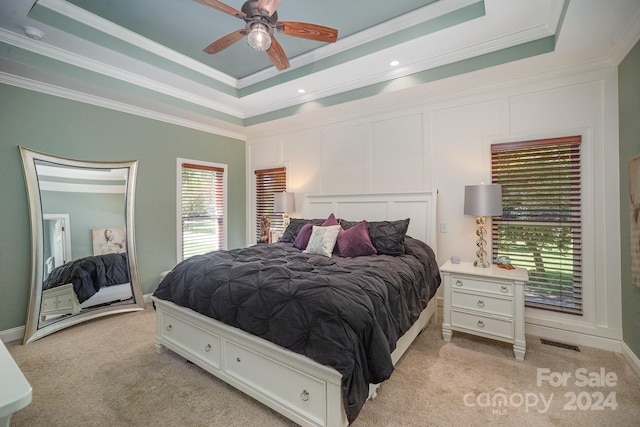 bedroom with a tray ceiling, ceiling fan, and crown molding