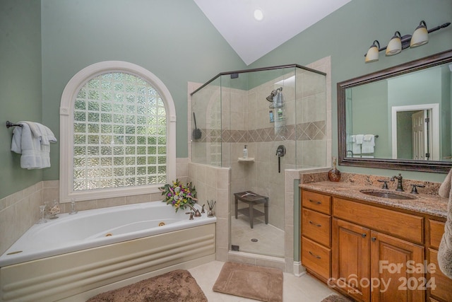 bathroom with tile patterned floors, vanity, vaulted ceiling, and independent shower and bath