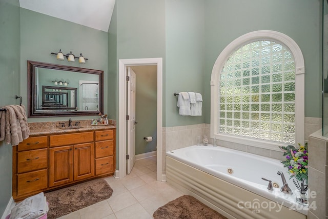 bathroom featuring a tub to relax in, tile patterned floors, vanity, and lofted ceiling