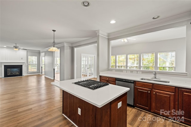 kitchen with light wood-type flooring, a center island, stainless steel appliances, and sink