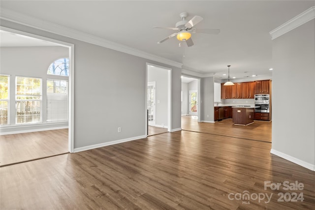 unfurnished living room with ceiling fan, crown molding, wood-type flooring, and vaulted ceiling