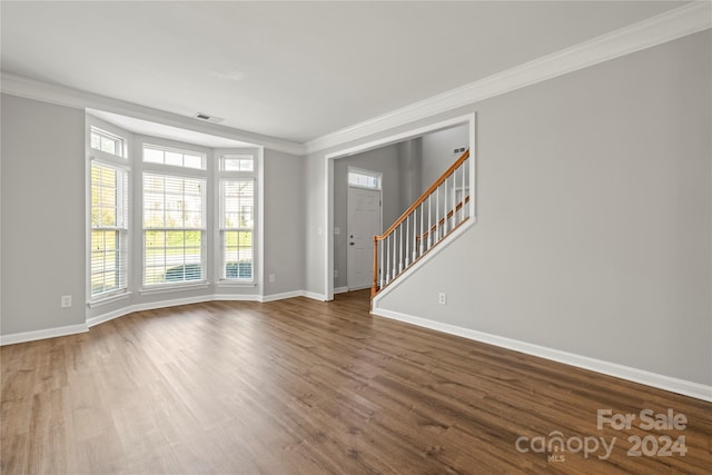 interior space featuring wood-type flooring and ornamental molding