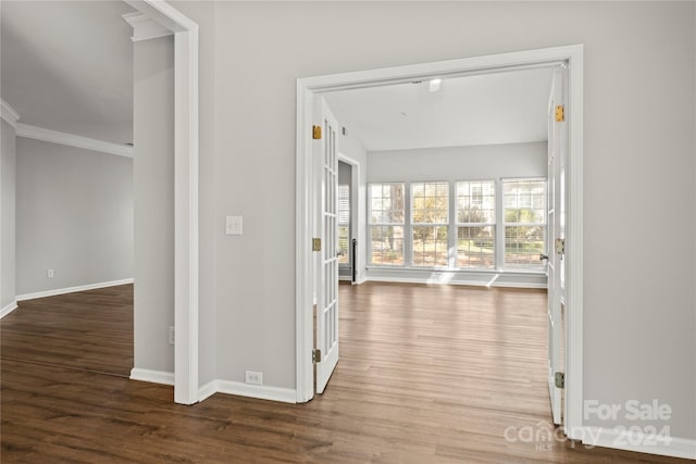 corridor with dark hardwood / wood-style flooring and ornamental molding