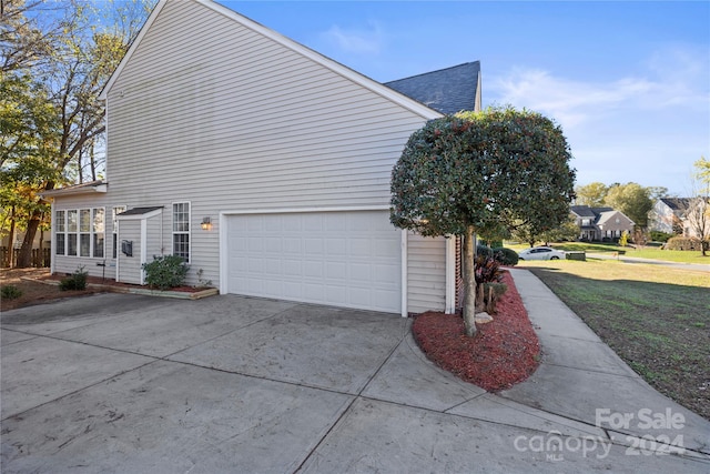 view of side of property with a lawn and a garage