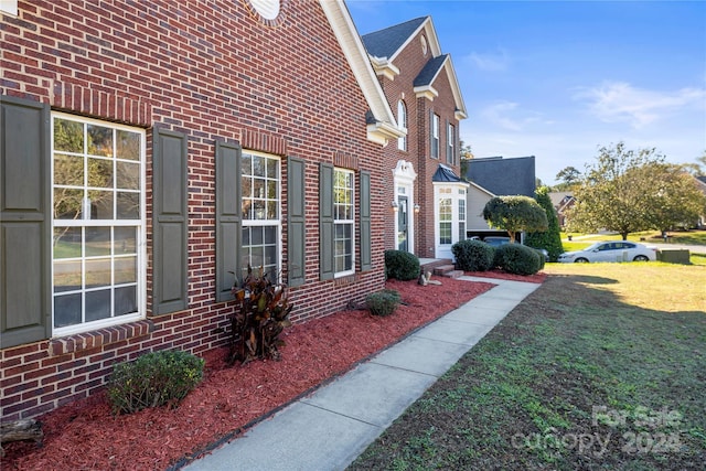 view of side of home featuring a lawn