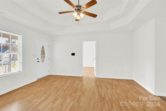 entrance foyer featuring a tray ceiling, light hardwood / wood-style flooring, and ceiling fan