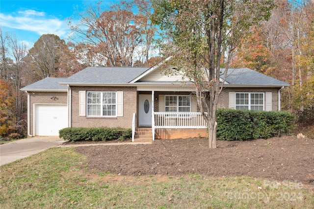 ranch-style home featuring covered porch and a garage