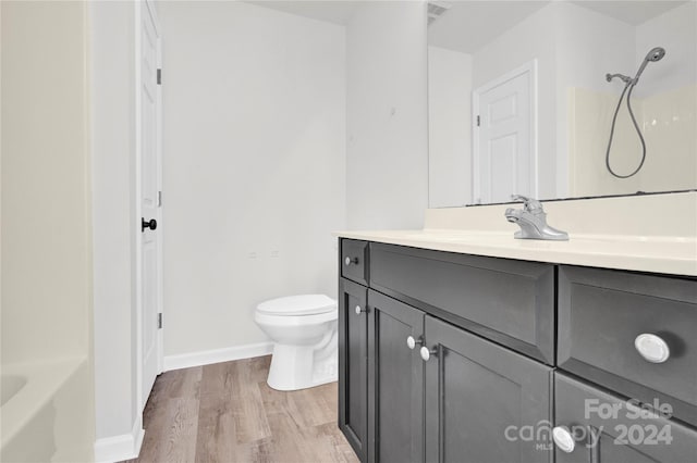 bathroom with toilet, vanity, and hardwood / wood-style flooring