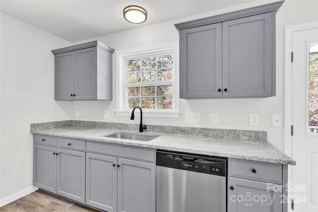 kitchen with gray cabinets, dishwasher, light wood-type flooring, and sink