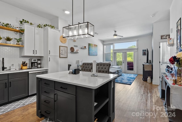 kitchen featuring ceiling fan, a center island, dishwasher, light hardwood / wood-style flooring, and white cabinets